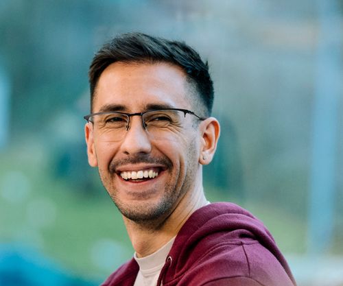 Sympathischer Mann mit entspanntem Lächeln vor moderner Glasfassade – steht für praxisnahe, qualitativ hochwertige VdS-Fortbildungen mit erstklassigen Referenten.