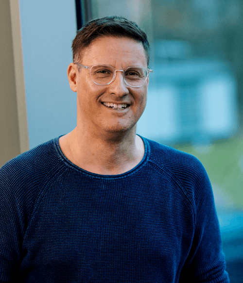 Sympathischer Mann mit entspanntem Lächeln vor moderner Glasfassade – steht für praxisnahe, qualitativ hochwertige VdS-Fortbildungen mit erstklassigen Referenten.