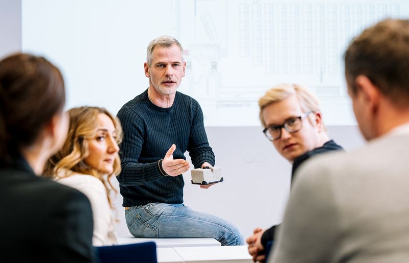 Dozent im VdS-Lehrgang erklärt Teilnehmenden praxisnah die Anwendung von Thermografie anhand eines Bauteilmodells vor technischer Skizze.